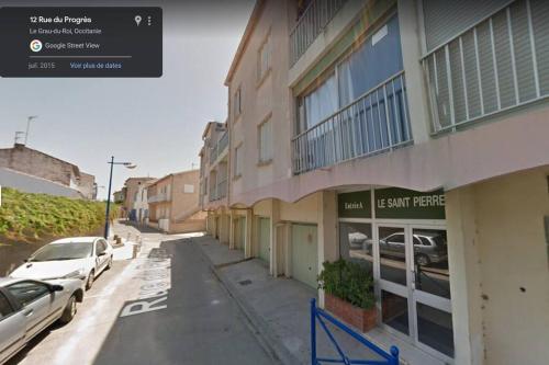 une rue avec des voitures garées devant un bâtiment dans l'établissement Studio de 18m² rénové en 2023., au Grau-du-Roi