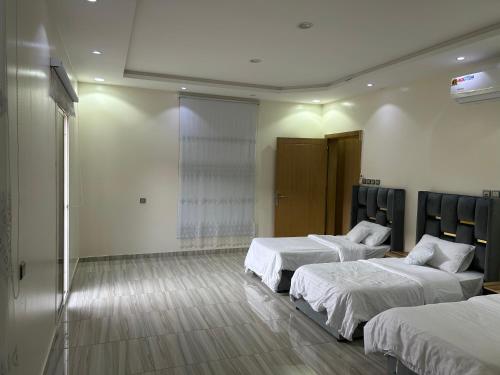 una camera con due letti in una camera con di فيلا قمرية الهدا ad Al Hada