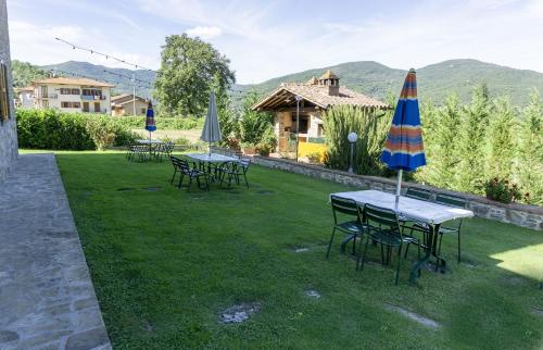 eine Gruppe von Tischen und Sonnenschirmen auf einem Rasen in der Unterkunft Villa Fornace in Casella