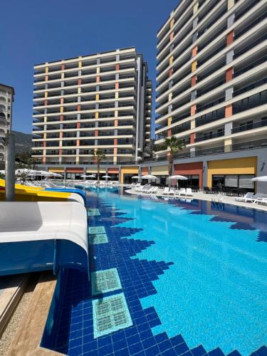 a large swimming pool next to a large building at Vesta Star in Alanya