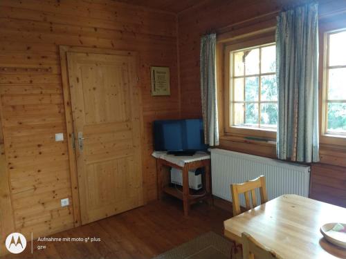 Habitación con mesa y TV en una cabina. en Rauter in Wöllan, en Arriach