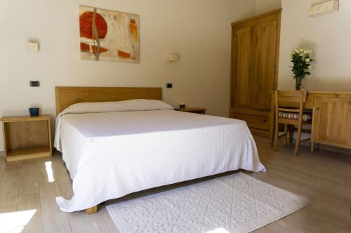 a bedroom with a bed and a table and a chair at Villa Fornace by Mmega in Casella