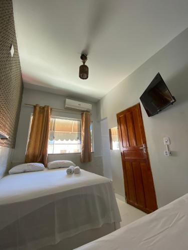 a bedroom with a bed and a tv on the wall at Hotel Dallas Ipiranga in Bom Jesus da Lapa