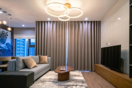 ein Wohnzimmer mit Couch und Flachbildfernseher in der Unterkunft NK#Homestay#Vinhomes#Oceanpark#2PN#C29 in Gia Lâm Pho