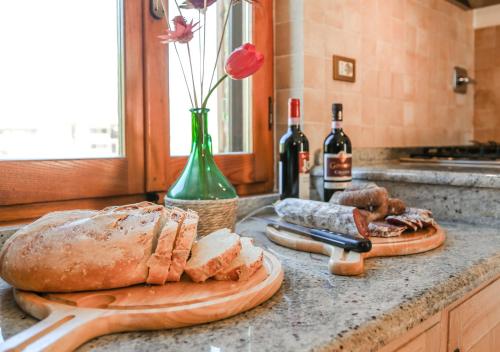 a kitchen counter with a loaf of bread and wine bottles at Villa Fornace by Mmega in Casella