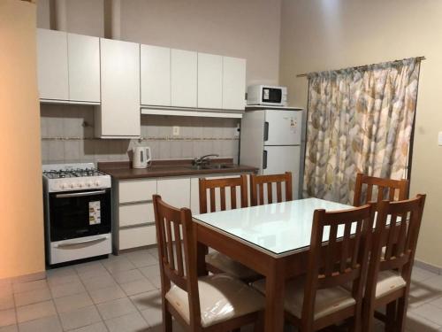 Il comprend une cuisine équipée d'une table, de chaises et d'une cuisinière. dans l'établissement Apartamentos María, à San Rafael