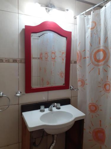 y baño con lavabo, espejo y cortina de ducha. en RUKAFUCHA en Mendoza