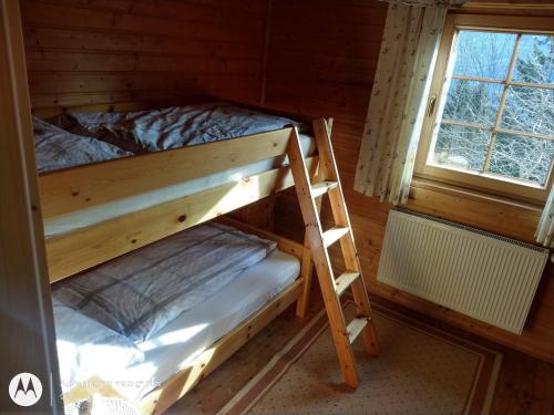ArriachにあるRauter in Wöllanの窓付きの木製の部屋の二段ベッド1台分です。