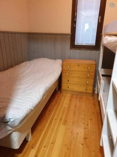 a small bedroom with a bed and a dresser at Kraatterimökki in Lappajärvi