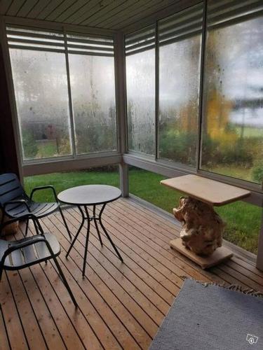 a screened in porch with a table and chairs at Kraatterimökki in Lappajärvi