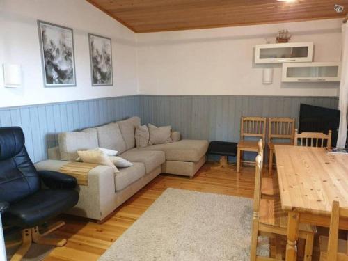 uma sala de estar com um sofá e uma mesa em Kraatterimökki em Lappajärvi