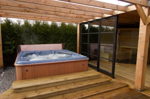 a hot tub sitting on a wooden deck at Luxurious Family Villa with sauna big garden and jacuzzi in Zeewolde