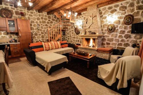 a living room with a couch and a fireplace at Filanthi in Kato Trikala Korinthias