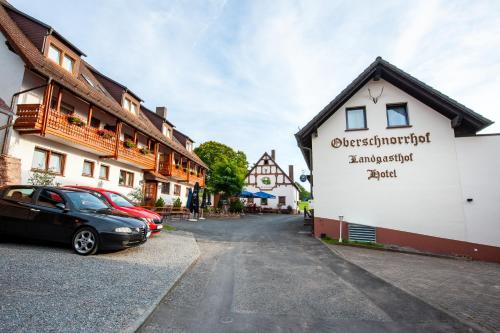 a street in a town with buildings and a car at Hotel Landgasthof Oberschnorrhof in Dammbach