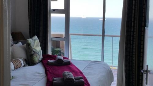a bedroom with a bed with a view of the ocean at Sands Beach Breaks Umdloti Beach View in Umdloti
