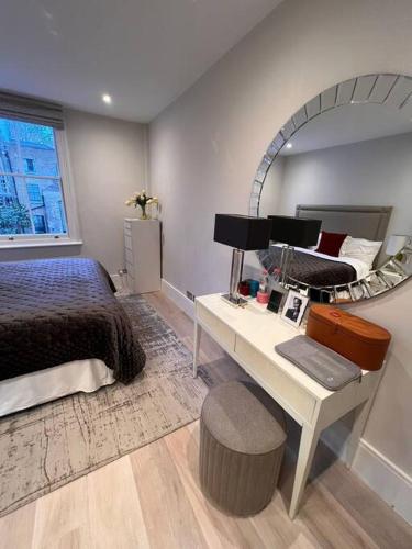 倫敦的住宿－One bedroom flat in Chelsea，一间卧室配有一张床和一张带镜子的书桌