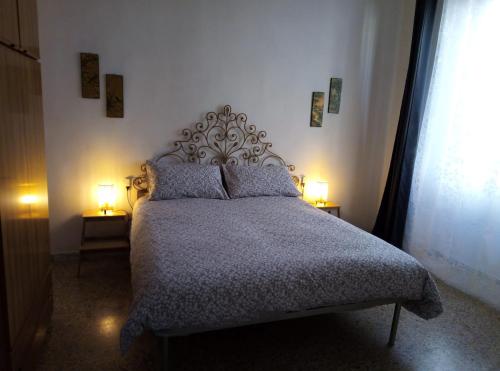 a bedroom with a bed with two lamps on two tables at L'OZioRinco in Florence
