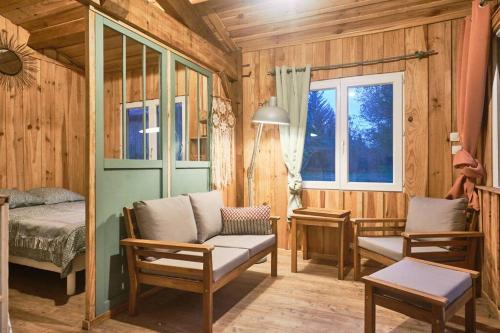 uma sala de estar com um sofá, uma cama e uma janela em Gîte familial en pleine nature- Domaine Temali em Labouheyre