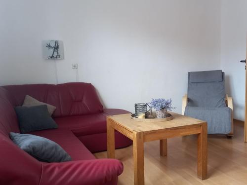 StormbruchにあるWohnung in Stormbruch nahe dem Skigebietのリビングルーム(赤いソファ、木製テーブル付)