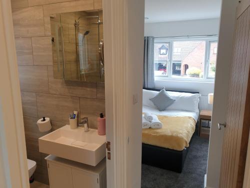 a bathroom with a bed and a sink and a mirror at Marlow's Emerald 3 Bedroom House in Marlow