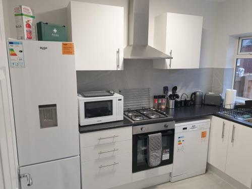 uma cozinha com electrodomésticos brancos e um micro-ondas branco em Chester le Street Amethyst 3 Bedroom House em Chester-le-Street