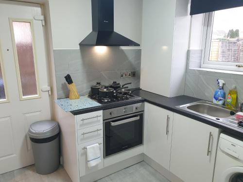 a small kitchen with a stove and a sink at South Shield's Diamond 3 Bedroom House Sleeps 6 in South Shields
