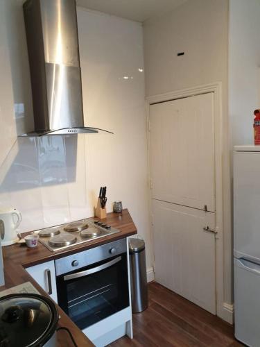 a kitchen with a stove top oven next to a door at South Shield's Hidden Gem Garnet 3 Bedroom Apartme in South Shields