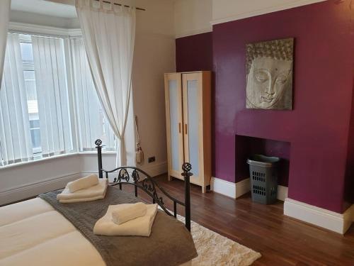 a bedroom with a large bed with purple walls at South Shield's Hidden Gem Garnet 3 Bedroom Apartme in South Shields