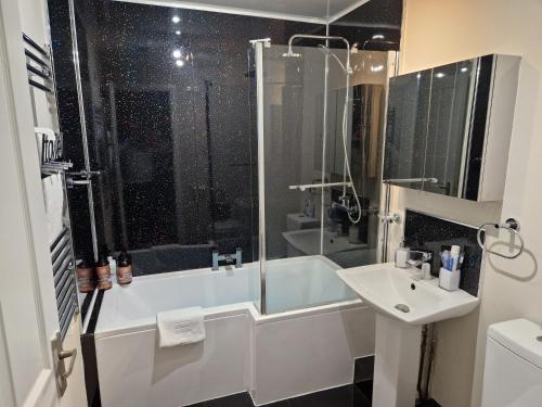 y baño con bañera, lavamanos y ducha. en Washingtons Emerald 2 Bed Exec Apt en Washington