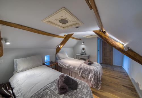 een slaapkamer met 2 bedden op een zolder bij Putsborough Manor 3 Self Catering Cottages with Beach a short walk, dog friendly all year, On site Tennis, Play Area, Paddock, Spa baths, BBQ, Private Gardens, Superfast WIFI in Croyde