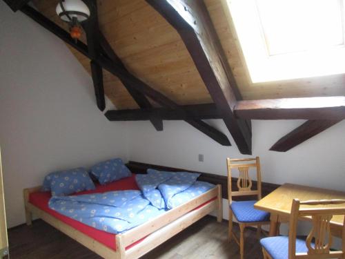Schlafzimmer mit einem Bett, einem Tisch und Stühlen in der Unterkunft Chalupa Annenské stráně in Horní Vltavice