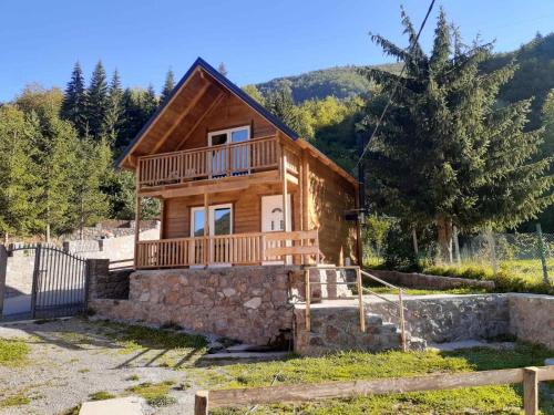 a log house with a porch and a balcony at Villas Meti Rugove in Peje