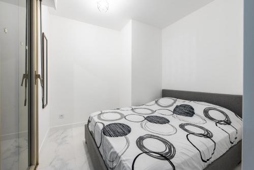 łóżko z czarno-białą kołdrą w pokoju w obiekcie VILLA CLIPPER w mieście Juan-les-Pins