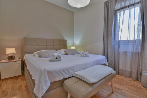 um quarto com uma grande cama branca e uma janela em Janamari em Zadar