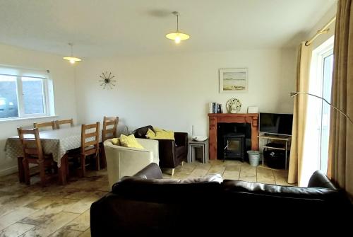 ein Wohnzimmer mit einem Sofa und einem Tisch in der Unterkunft Cluain Uilinn in Miltown Malbay