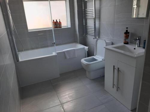 a bathroom with a tub and a toilet and a sink at South Shield's Hidden Gem Amethyst 3 Bedroom House in South Shields