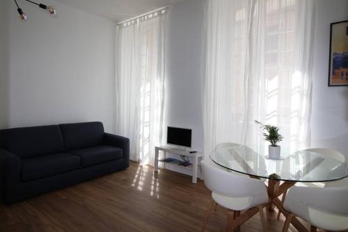 un salon avec une table en verre et un canapé dans l'établissement Quartier Historique du Château bel appt meublé, à Pau