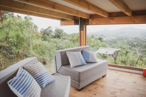 a living room with a couch and a large window at Chocó 701 La Reserva- Casa Loft in Culantropamba