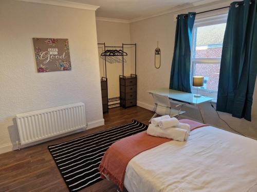 a bedroom with a bed and a desk and a window at Chester Le Street's Diamond 3 Bed House in Chester-le-Street