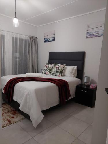 a bedroom with a large bed with a black headboard at Craiden Holiday Apartment at The Blyde Crystal Lagoon 2 bedrooms in Pretoria