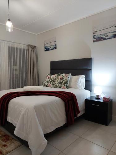 1 dormitorio con 1 cama grande y cabecero negro en Craiden Holiday Apartment at The Blyde Crystal Lagoon 2 bedrooms en Pretoria