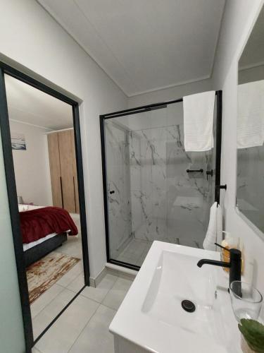 een badkamer met een witte wastafel en een douche bij Craiden Holiday Apartment at The Blyde Crystal Lagoon 2 bedrooms in Pretoria