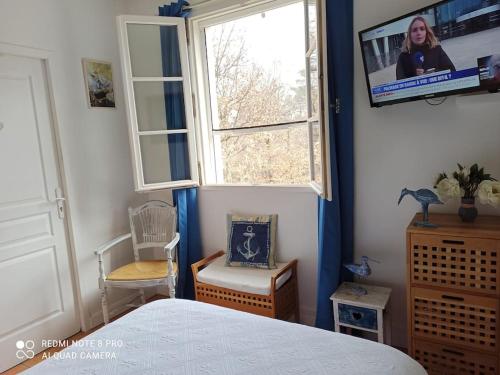 une chambre avec un lit, une télévision et une fenêtre dans l'établissement La Rose des Claux, à Fayence