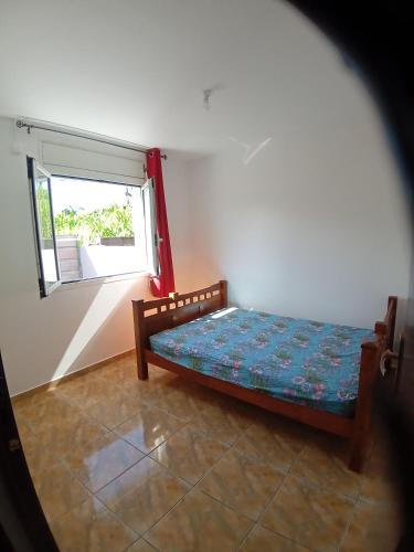 een kleine slaapkamer met een bed en een raam bij Sababady Villa 3 chambres in Saint-André
