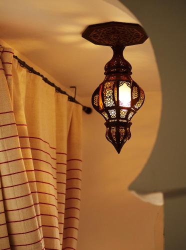 a light hanging from a ceiling next to a curtain at Dar Said in Asilah