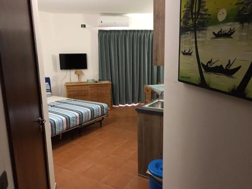 a bedroom with a bed and a sink and a television at studio's Porto Antigo 2 in Santa Maria