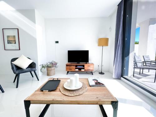 uma sala de estar com uma mesa e uma televisão em Apartment in Manilva, just a few steps from the beach em Manilva