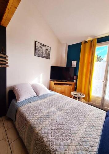 une chambre avec un lit et une télévision à écran plat dans l'établissement Chez Aurore & Jérémy en Vendée - Jolie maison cosy tout près des plages de l'Atlantique, à Saint-Hilaire-de-Riez