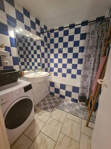 La salle de bains est pourvue d'un mur en damier bleu et blanc. dans l'établissement Chez Aurore & Jérémy en Vendée - Jolie maison cosy tout près des plages de l'Atlantique, à Saint-Hilaire-de-Riez