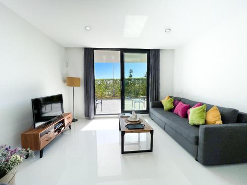 uma sala de estar com um sofá e uma televisão em Apartment in Manilva, just a few steps from the beach em Manilva